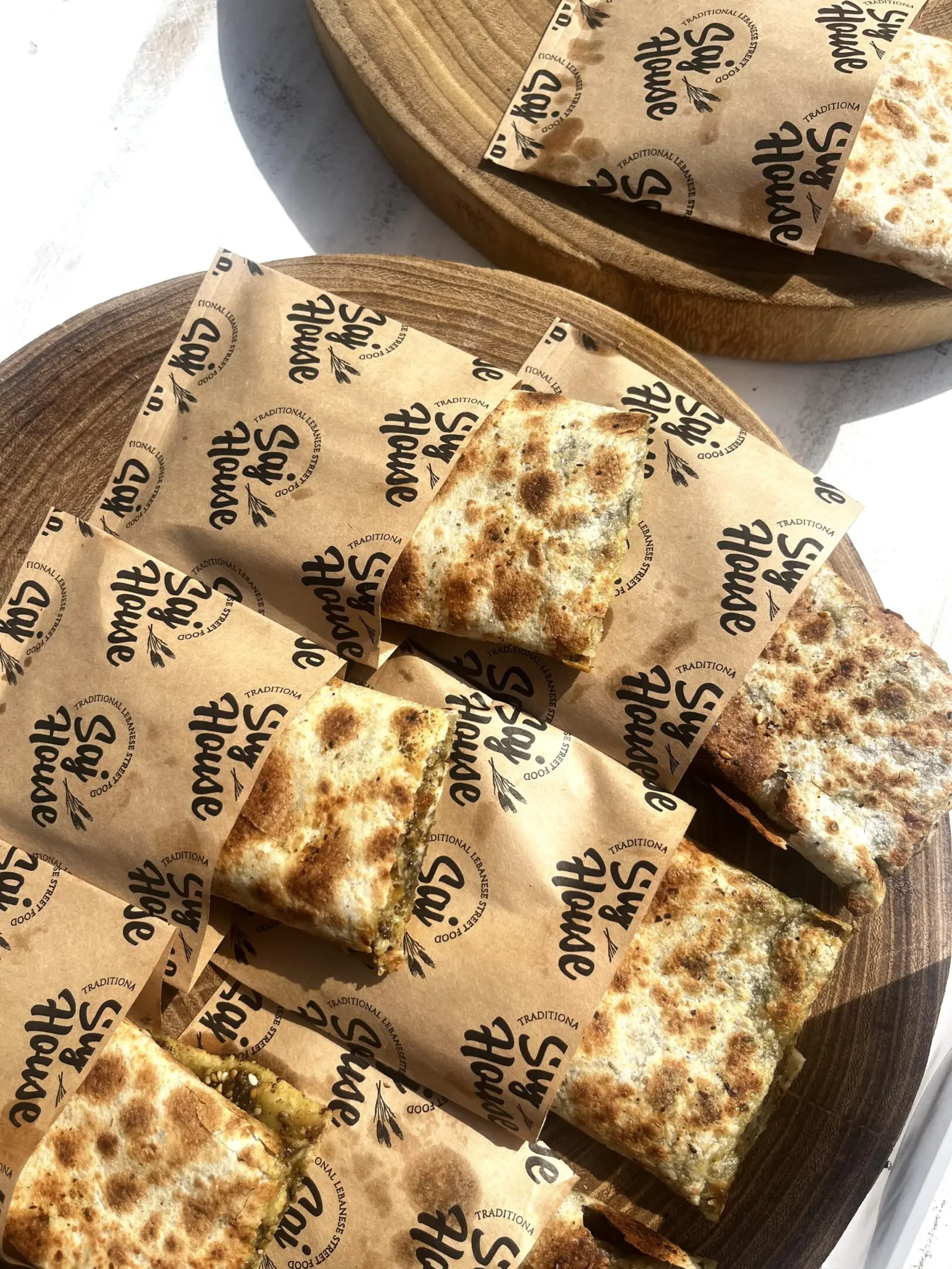 Grilled sandwiches with melted cheese on branded paper.