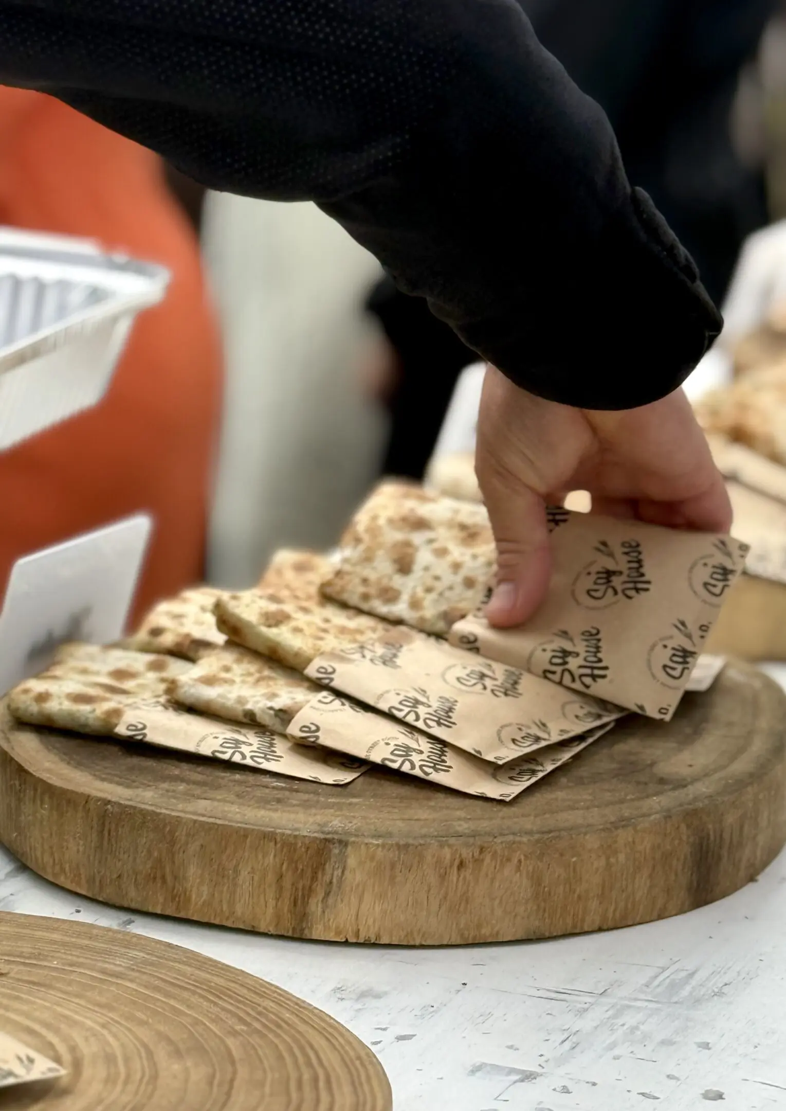 Hand picking a card from a deck of playing cards on a wooden board.