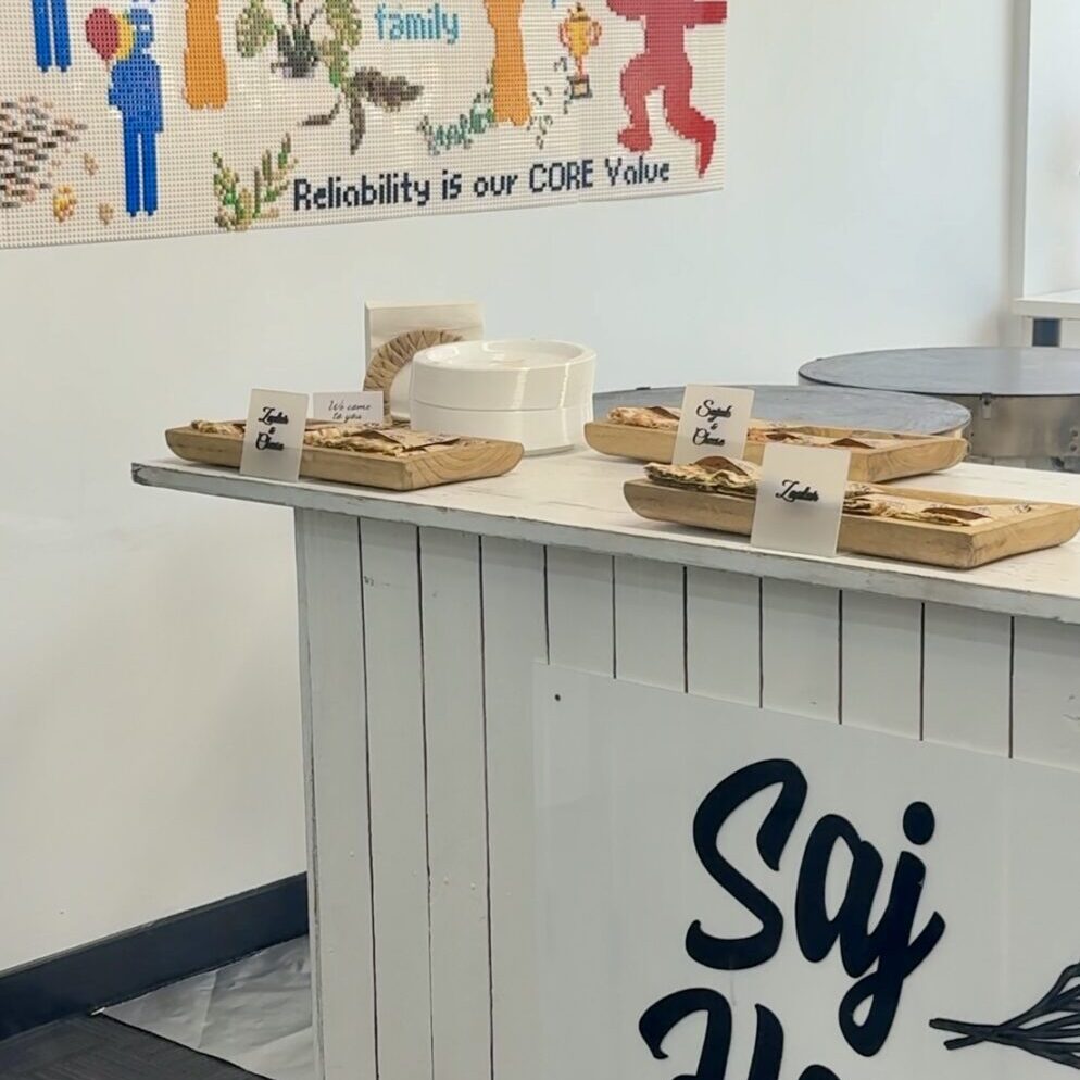 A cozy café counter with wooden trays and a colorful wall poster.