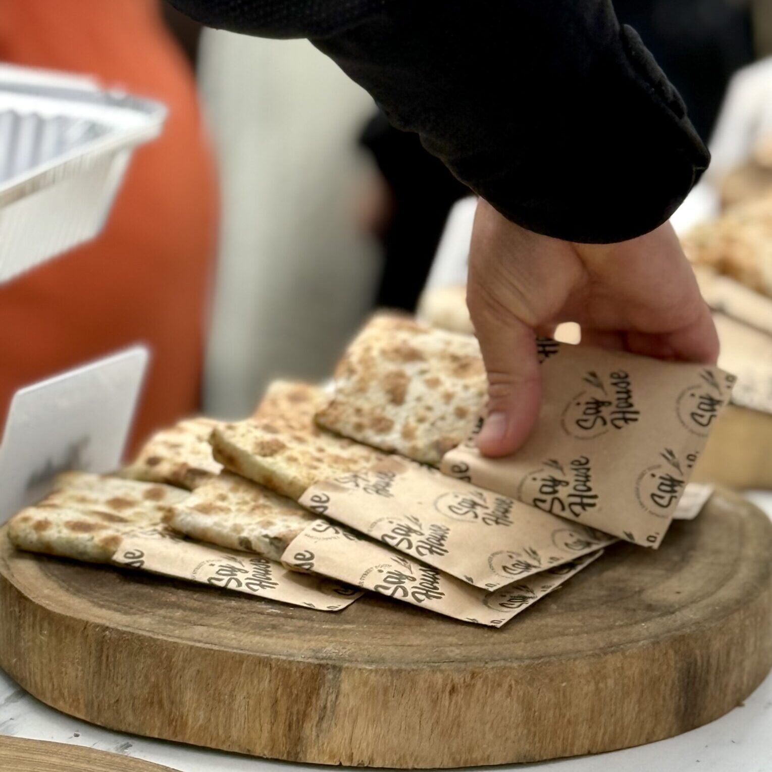 Hand picking a card from a deck of playing cards on a wooden board.